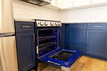A blue oven with a glass door is in a kitchen. at The Crest at Oakwood Apartments, Georgia, 30566